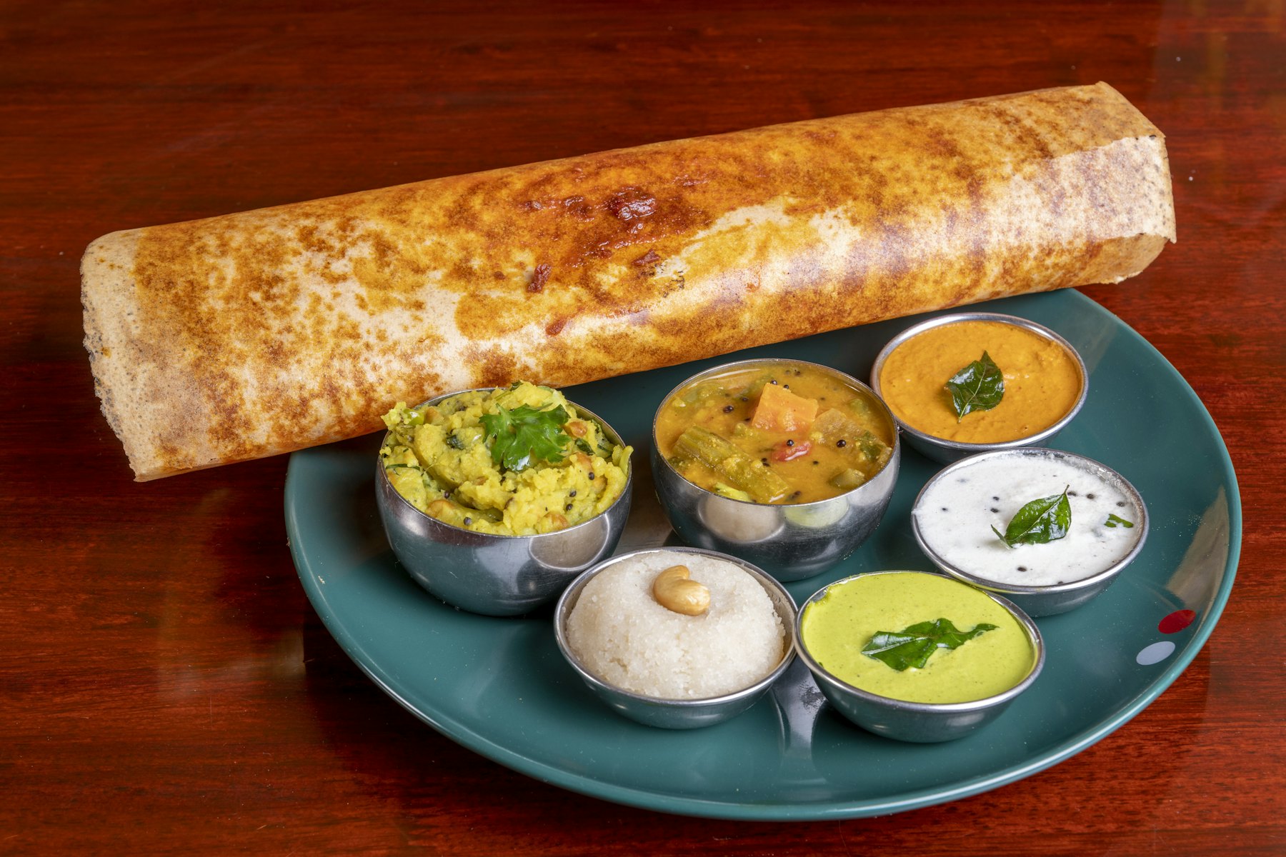 Ghee roast dosa served with sambar and three chutneys